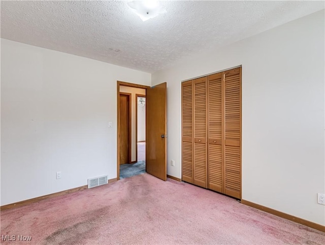 unfurnished bedroom with carpet, visible vents, a closet, and baseboards