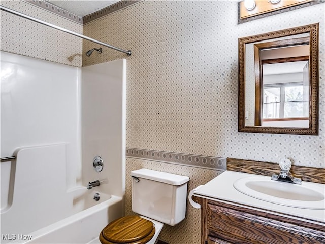 full bathroom with toilet, wallpapered walls, vanity, and bathtub / shower combination