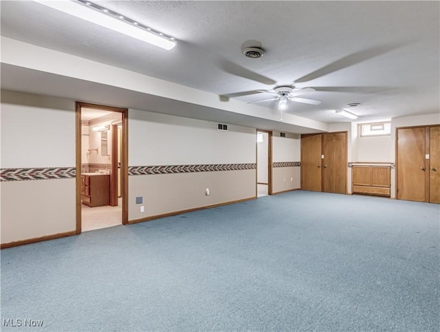 spare room featuring visible vents, baseboards, light colored carpet, and a textured ceiling