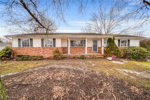 single story home featuring brick siding and a porch