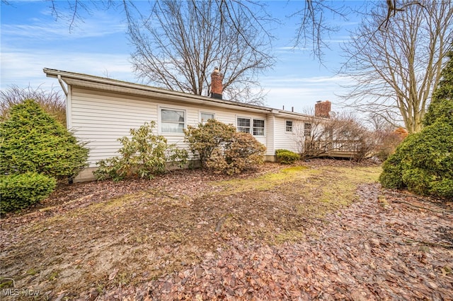 rear view of property featuring a chimney