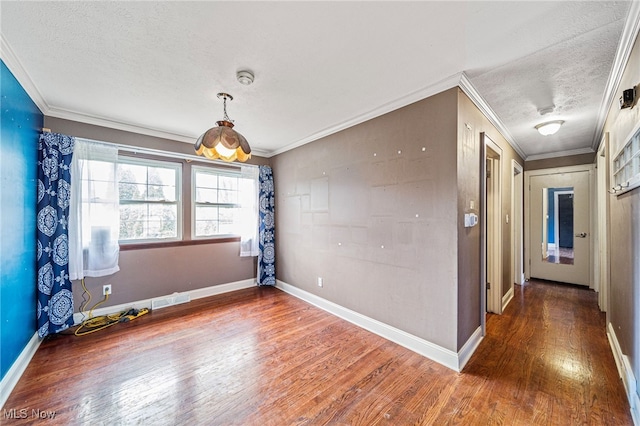 empty room with wood finished floors, baseboards, visible vents, a textured ceiling, and crown molding