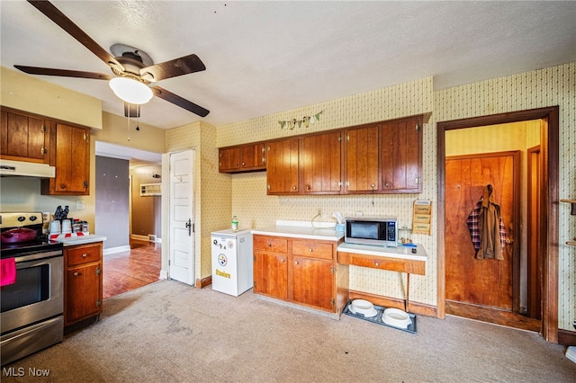 kitchen featuring under cabinet range hood, wallpapered walls, stainless steel appliances, and ceiling fan