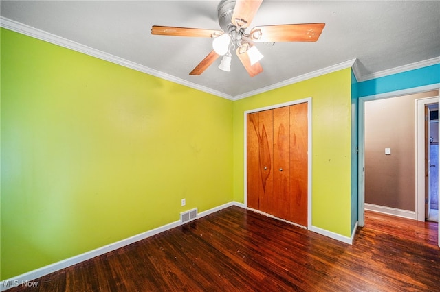 unfurnished bedroom featuring visible vents, wood finished floors, a closet, crown molding, and baseboards