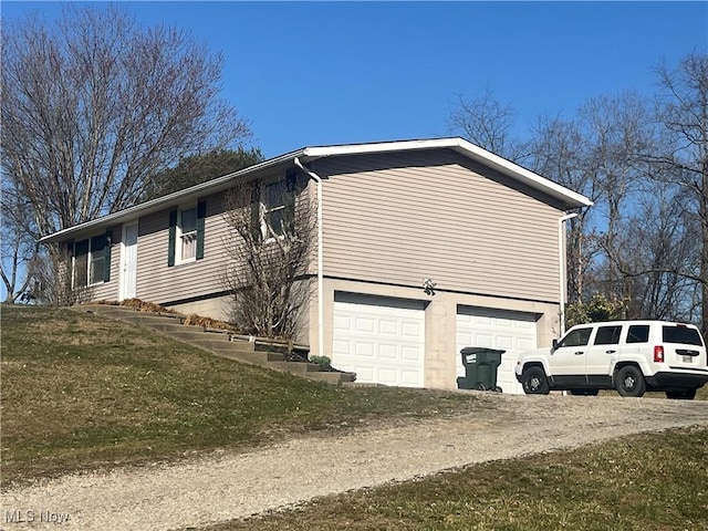 view of side of home featuring an attached garage and driveway