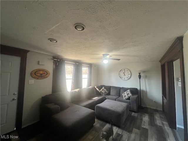 living room with a textured ceiling, a ceiling fan, and dark wood-style flooring