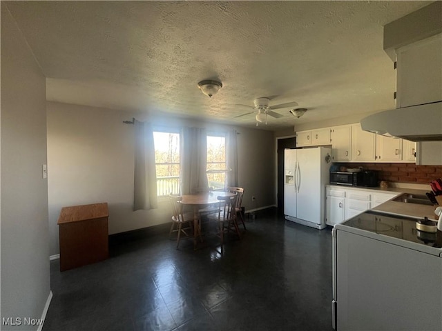 kitchen featuring range, white refrigerator with ice dispenser, white cabinets, a ceiling fan, and a sink