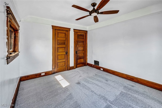 unfurnished bedroom featuring visible vents, baseboards, carpet, and a ceiling fan