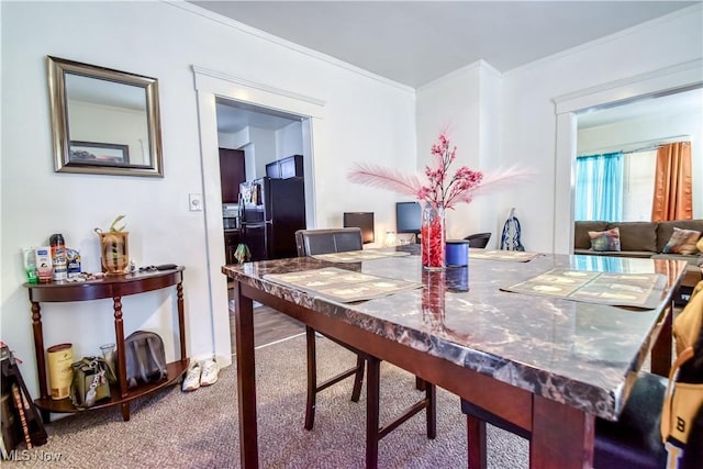 carpeted dining area featuring crown molding