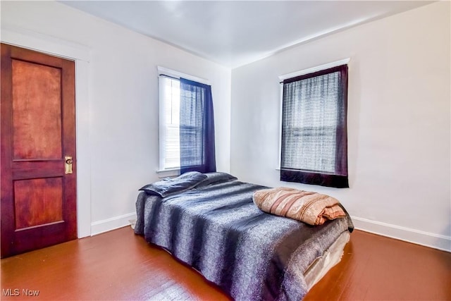 bedroom with baseboards and wood finished floors