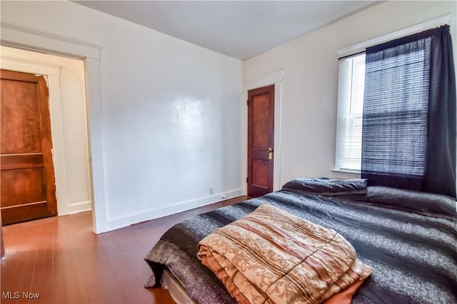 bedroom featuring baseboards and wood finished floors