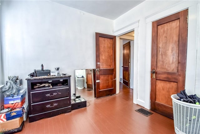 bedroom featuring visible vents and wood finished floors