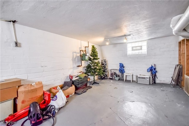 below grade area with a textured ceiling and concrete block wall