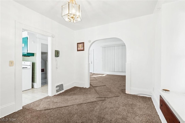 unfurnished room with visible vents, carpet floors, washer / clothes dryer, arched walkways, and a chandelier