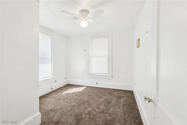 carpeted empty room featuring baseboards and ceiling fan