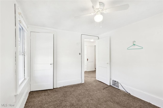 unfurnished bedroom featuring a ceiling fan, visible vents, carpet, and baseboards