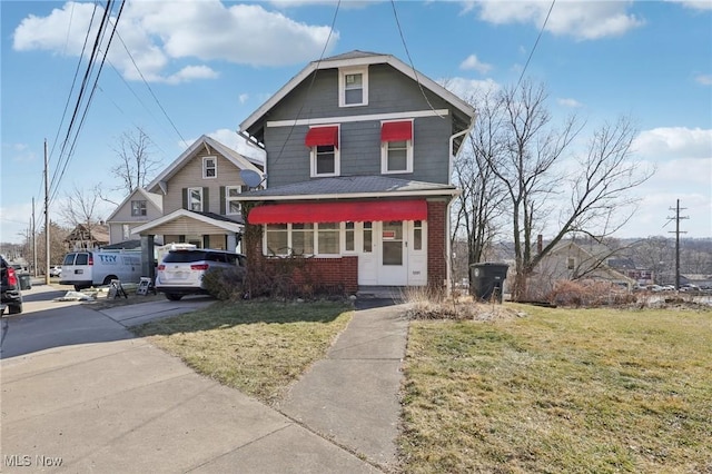 view of front of home with a front lawn and brick siding