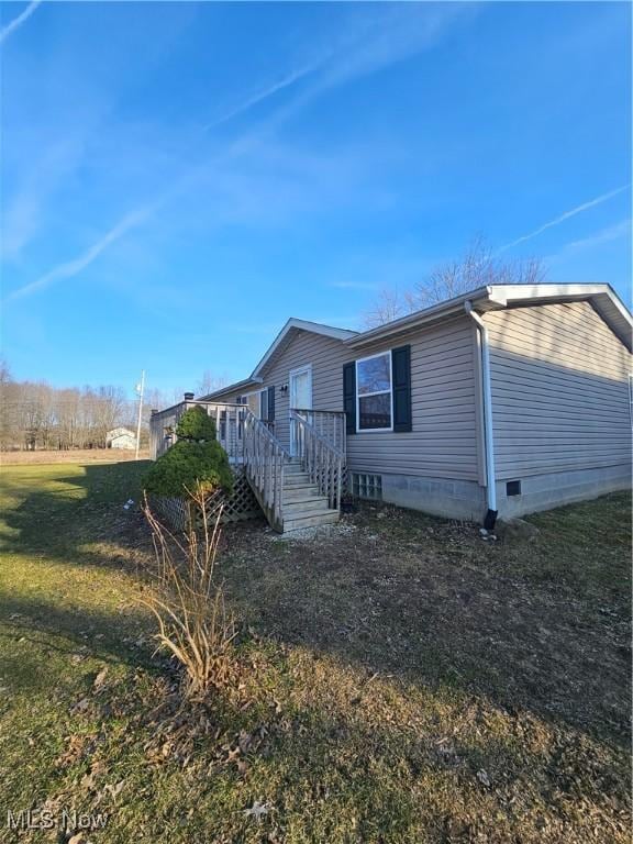 view of home's exterior with crawl space, a yard, and a wooden deck