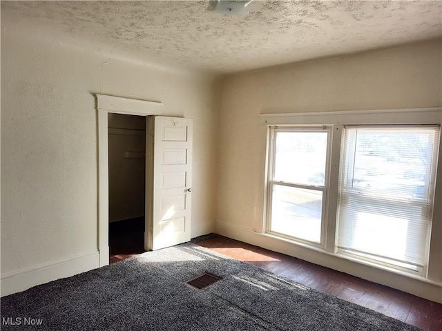 empty room featuring visible vents and a textured ceiling