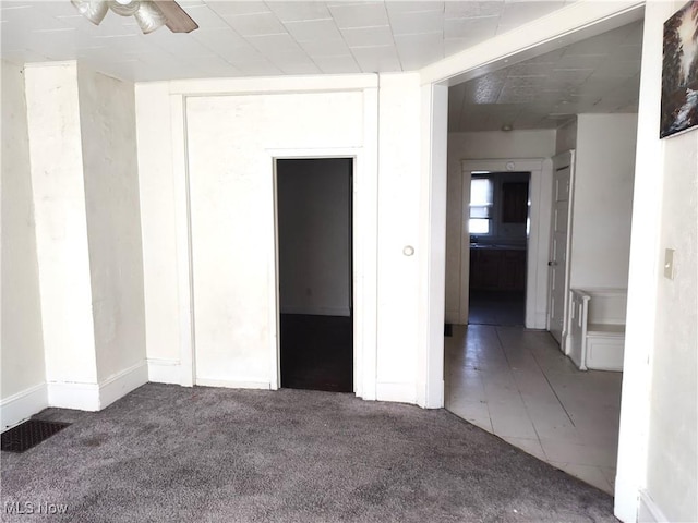 carpeted empty room featuring a ceiling fan and visible vents