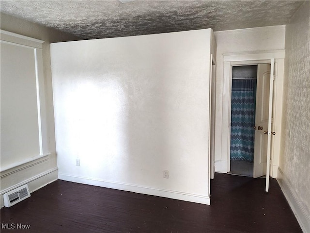 unfurnished room with visible vents, baseboards, and wood finished floors