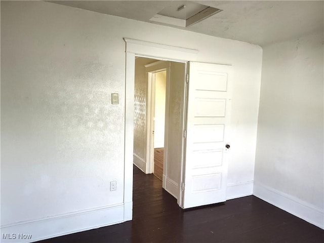 empty room with baseboards and dark wood-style flooring