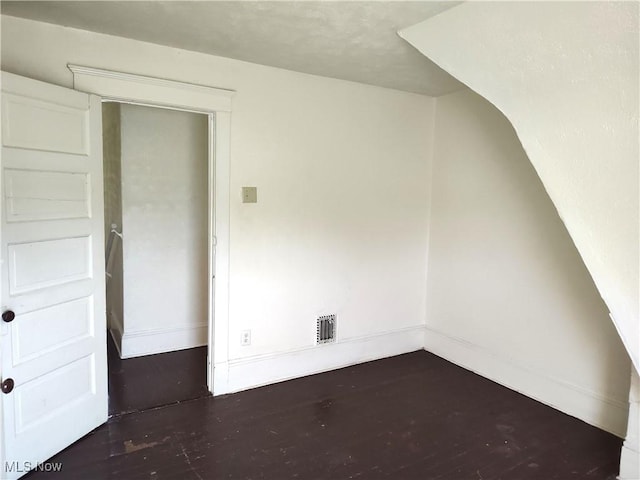 additional living space with visible vents, baseboards, and wood finished floors