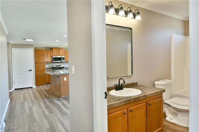 bathroom with vanity, wood finished floors, shower / tub combination, crown molding, and toilet