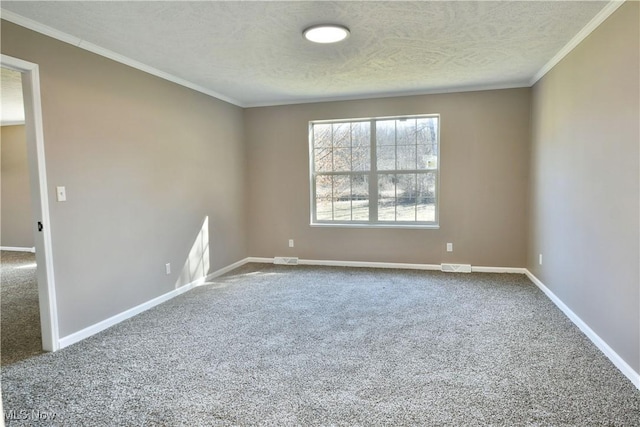 spare room with visible vents, ornamental molding, a textured ceiling, carpet flooring, and baseboards