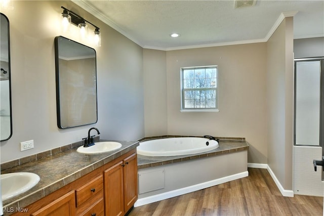 bathroom with crown molding, wood finished floors, visible vents, and a sink