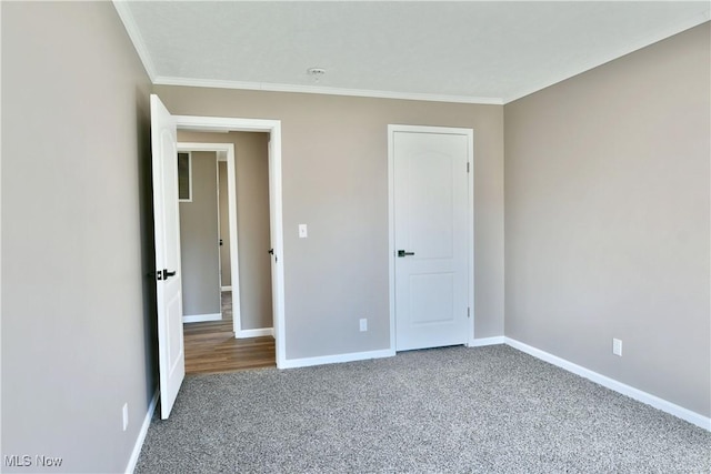 unfurnished bedroom featuring baseboards, carpet floors, and crown molding