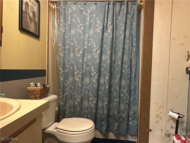 full bathroom featuring vanity, curtained shower, and toilet