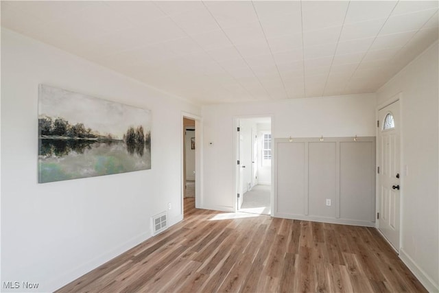 interior space featuring wood finished floors, visible vents, and baseboards