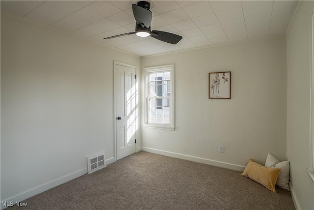 unfurnished bedroom with visible vents, a ceiling fan, carpet, crown molding, and baseboards