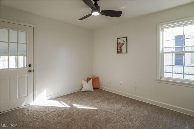 unfurnished room featuring carpet flooring, a ceiling fan, and baseboards