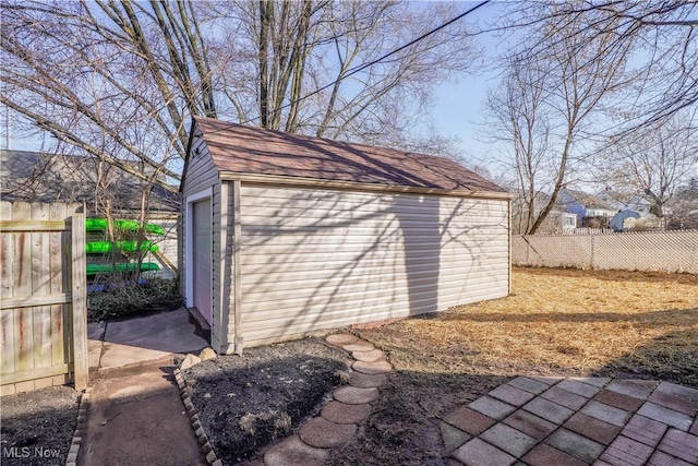 view of outbuilding featuring an outdoor structure and fence