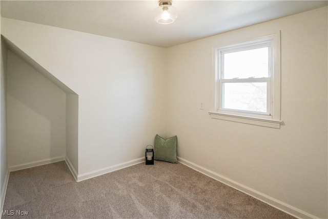 spare room with light colored carpet and baseboards