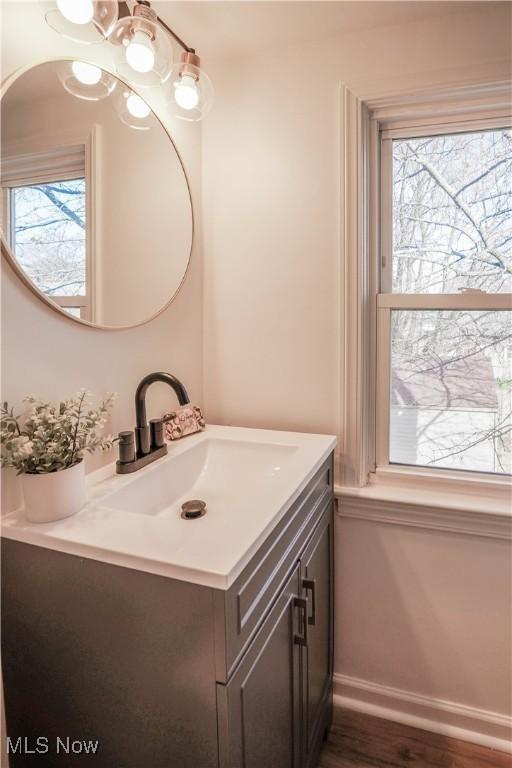 bathroom with vanity, wood finished floors, and baseboards