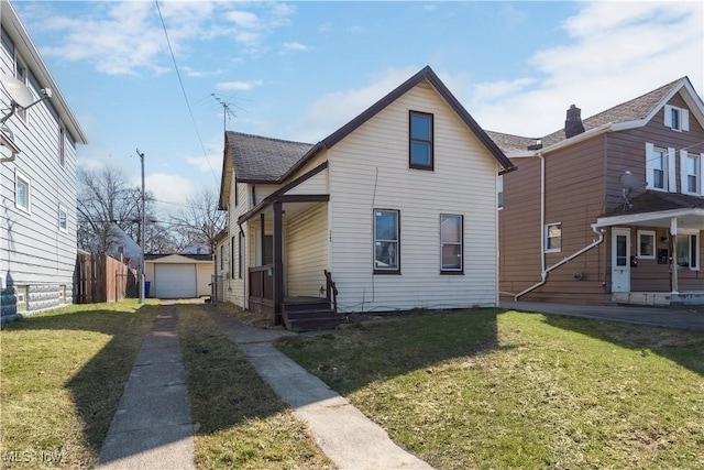 view of front of house with an outbuilding, driveway, fence, a front yard, and a garage