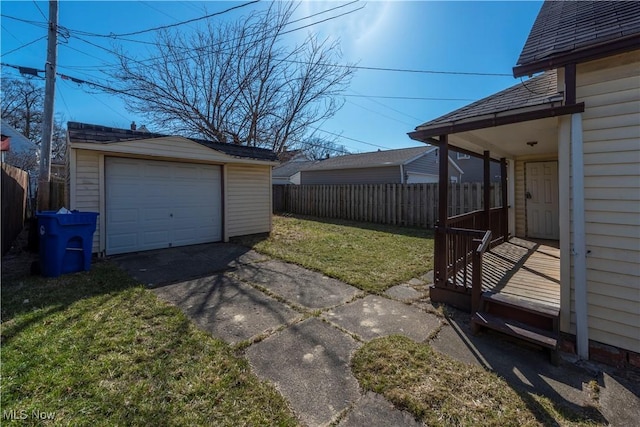 detached garage featuring driveway and fence