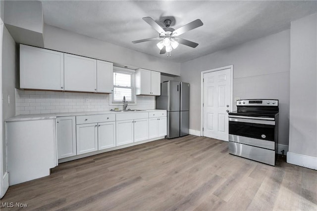 kitchen with ceiling fan, light countertops, white cabinets, stainless steel appliances, and a sink