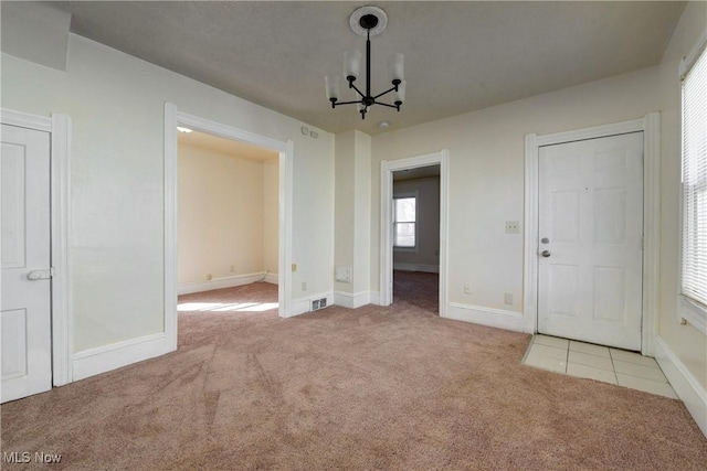 interior space with a notable chandelier, baseboards, and visible vents