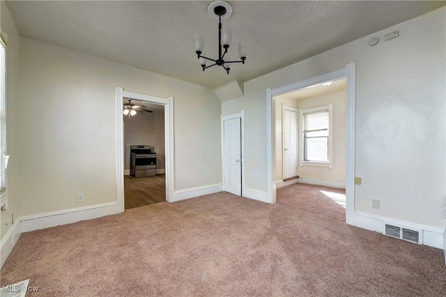 unfurnished bedroom featuring a notable chandelier, carpet flooring, baseboards, and visible vents