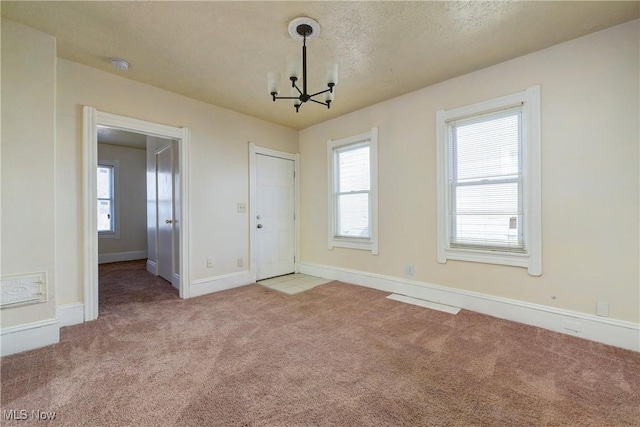 interior space with a notable chandelier, a textured ceiling, and baseboards