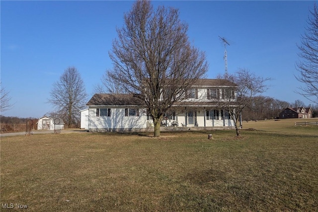 back of property featuring an outbuilding, a lawn, and a storage shed