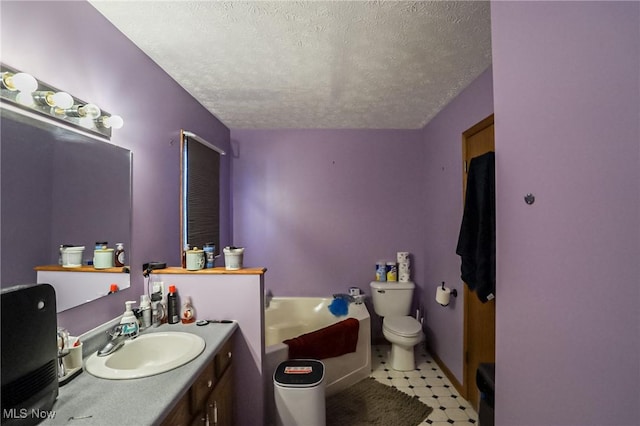 bathroom with vanity, toilet, a bath, and a textured ceiling