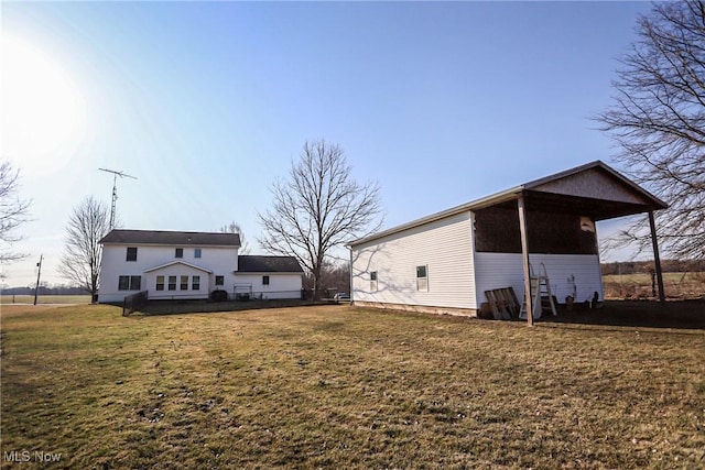 rear view of property featuring a carport and a lawn