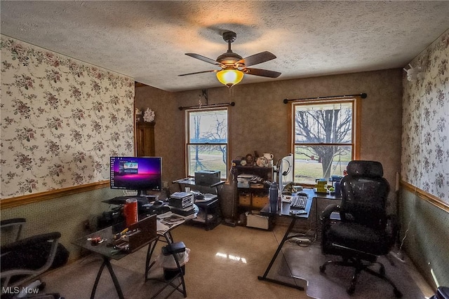 office space featuring a textured ceiling, a healthy amount of sunlight, ceiling fan, and wallpapered walls