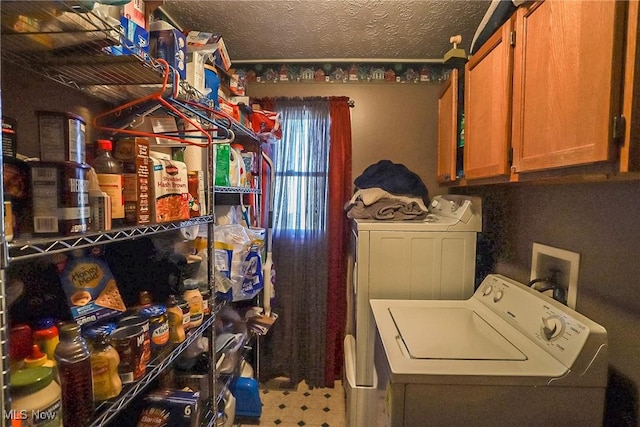 laundry room with separate washer and dryer, cabinet space, and a textured ceiling