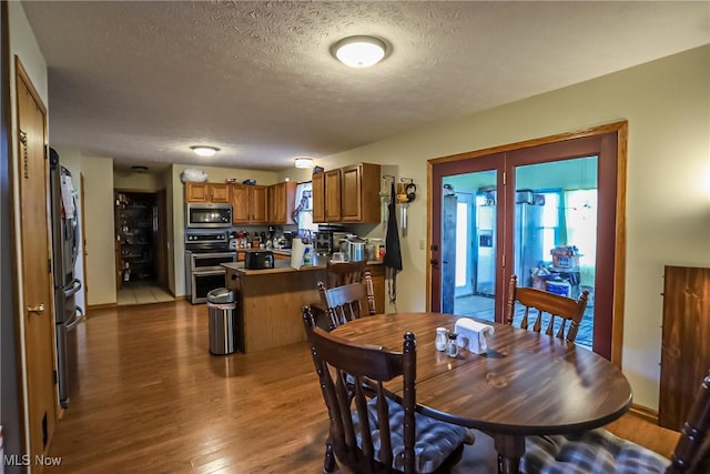 dining space featuring a textured ceiling and wood finished floors